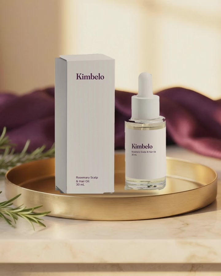 Short looping clip of the Kimbelo Rosemary Scalp & Hair Oil bottle and carton on a gold tray